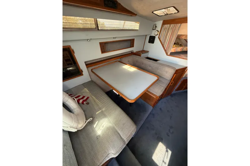 Slide: The Image of Interior of 1987 Sea Ray 300 Weekender with cozy seating and table. - 9
