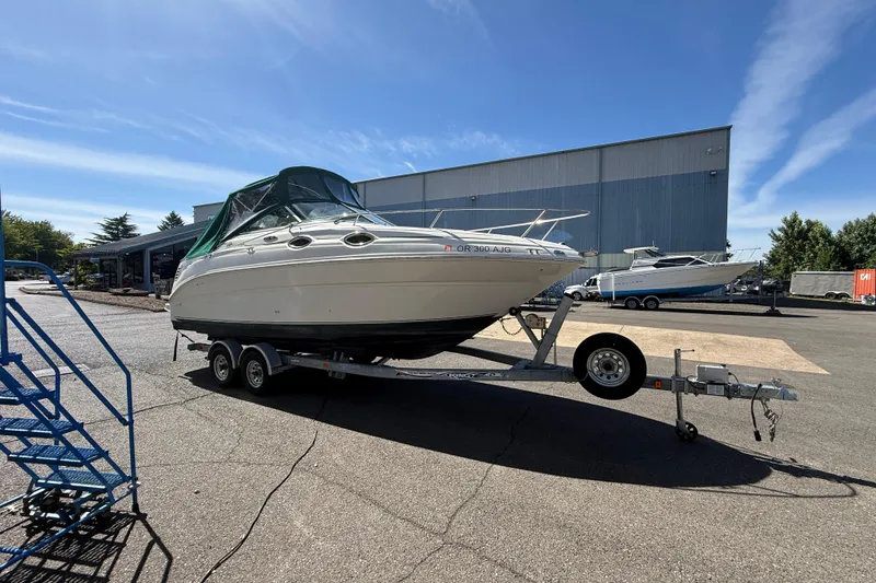 The Image of 2004 Sea Ray 240 Sundancer boat on trailer in outdoor storage area. - 0