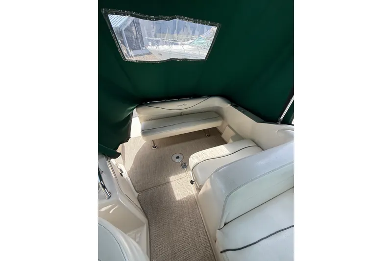 Slide: The Image of Interior view of 2004 Sea Ray 240 Sundancer with green canopy and white seating. - 10