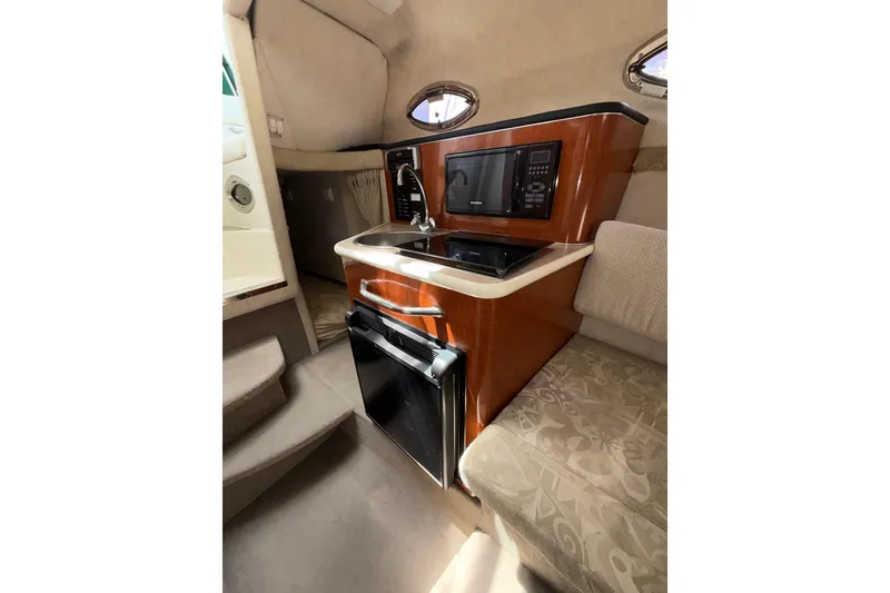Slide: The Image of Interior of 2004 Sea Ray 240 Sundancer boat with kitchenette and seating area. - 14
