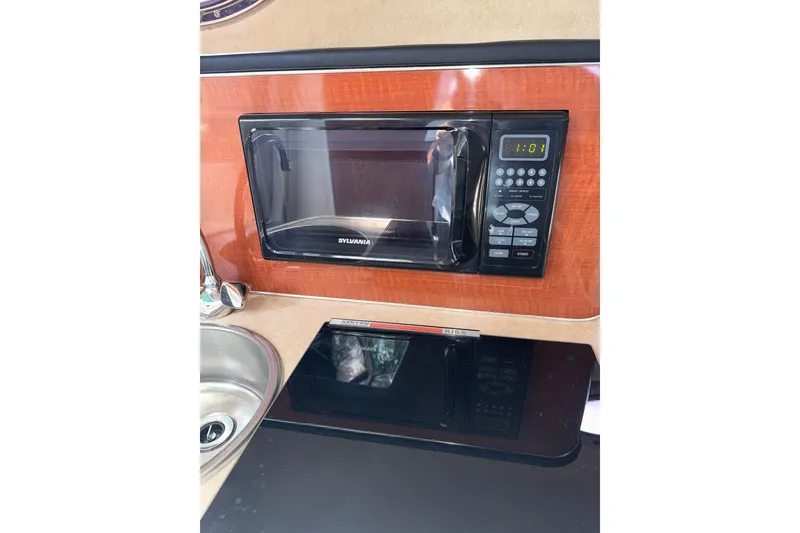 Slide: The Image of Microwave and sink in 2004 Sea Ray 240 Sundancer boat kitchen area. - 18