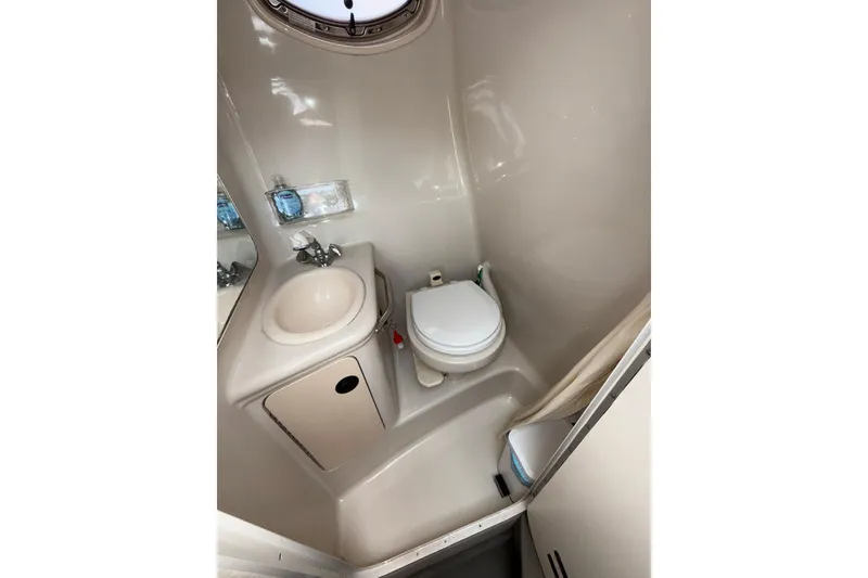 Slide: The Image of Compact bathroom in 2004 Sea Ray 240 Sundancer boat, featuring sink and toilet. - 19
