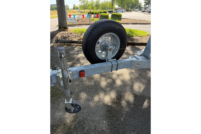 Slide: The Image of Trailer hitch and wheel for 2004 Sea Ray 240 Sundancer boat in parking lot. - 21