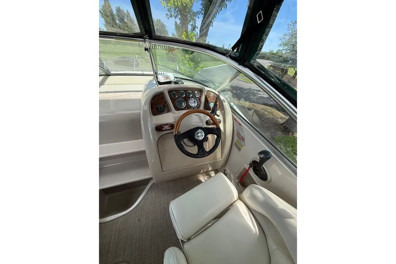 Slide: The Image of Interior view of 2004 Sea Ray 240 Sundancer boat cockpit with steering wheel and controls. - 5