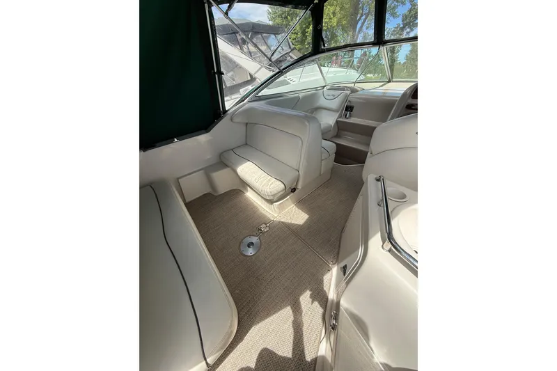 Slide: The Image of Interior of a 2004 Sea Ray 240 Sundancer boat, featuring beige seating and carpet. - 7