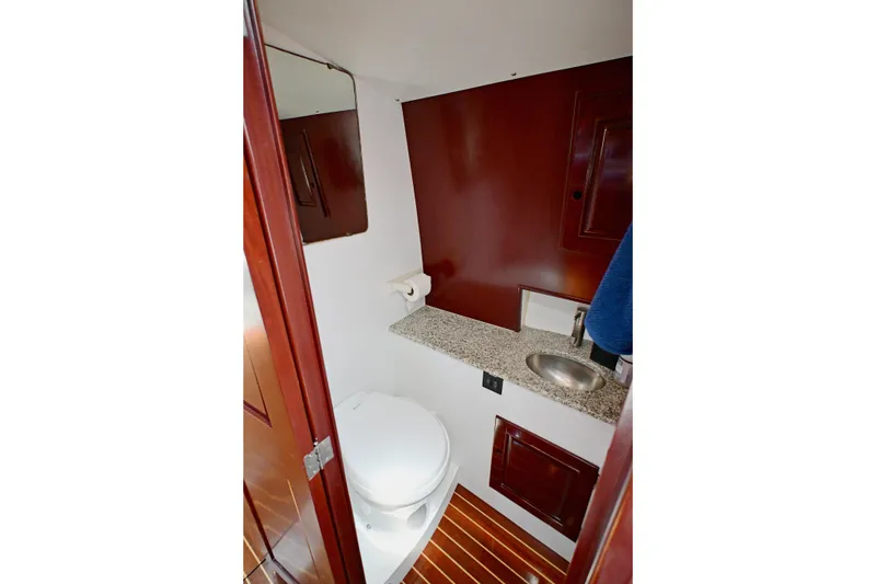 Slide: The Image of Elegant yacht bathroom with wooden accents, granite countertop, and compact sink, Abeking & Rasmussen Tripp 74, 1968. - 13