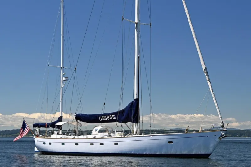 Slide: The Image of Vintage 1968 Abeking & Rasmussen Tripp 74 yacht sailing on calm waters under clear skies. - 52