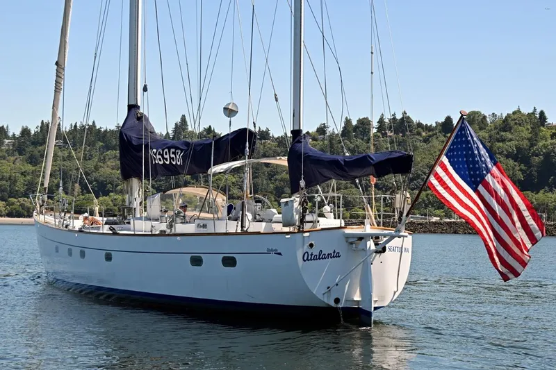 Slide: The Image of Sailing yacht "Atalanta" by Abeking & Rasmussen Tripp, 1968, with American flag, on serene water. - 55