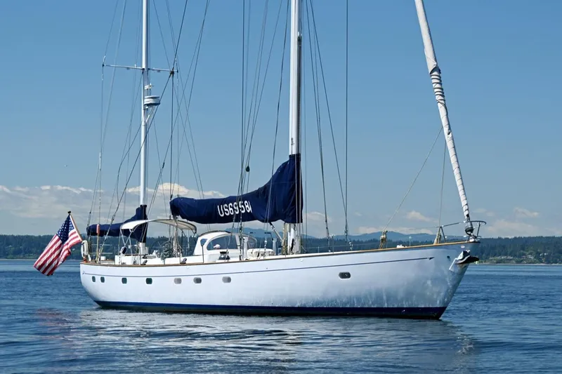 Slide: The Image of Sailing yacht Abeking & Rasmussen Tripp 74, 1968, on calm waters with American flag. - 57