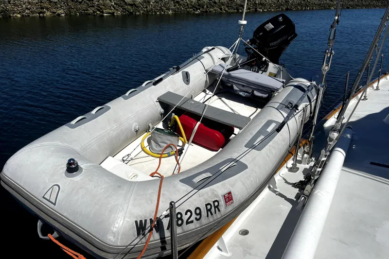 Slide: The Image of Inflatable boat docked beside Abeking & Rasmussen Tripp 74 yacht, 1968 model, on calm water. - 60