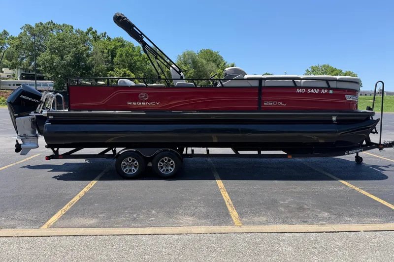 The Image of 2024 Regency R250DL3 pontoon boat on trailer in parking lot. - 0