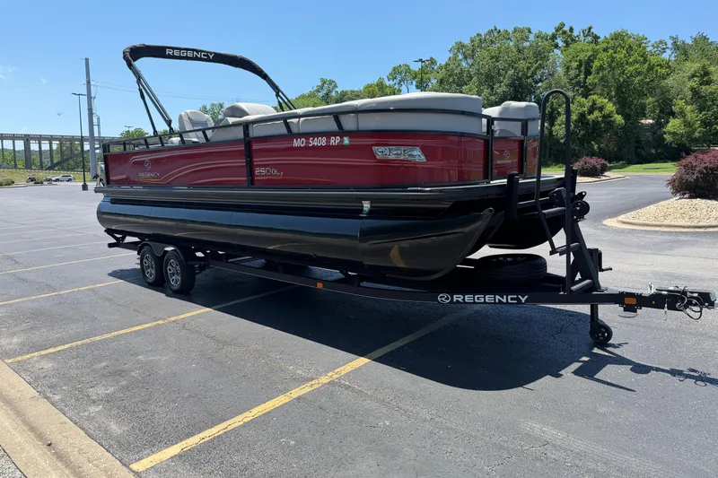 Slide: The Image of 2024 Regency R250DL3 pontoon boat on trailer in parking lot, sunny day. - 1