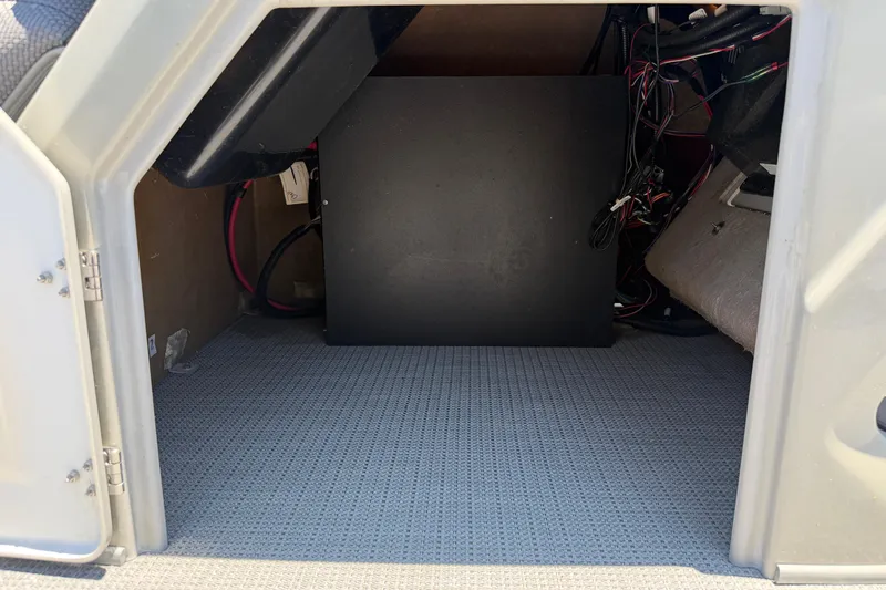 Slide: The Image of 2024 Regency R250DL3 storage compartment with wiring and carpeted floor. - 14