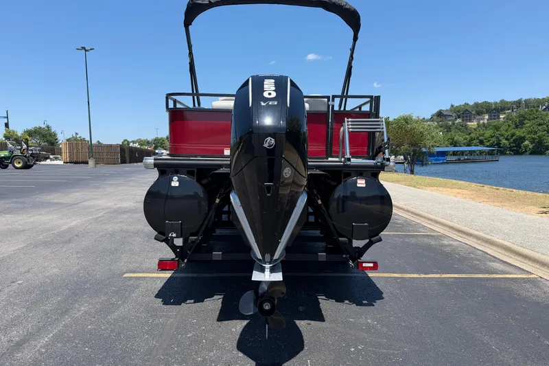 Slide: The Image of 2024 Regency R250DL3 pontoon boat with powerful outboard motor, parked near a scenic lake. - 5