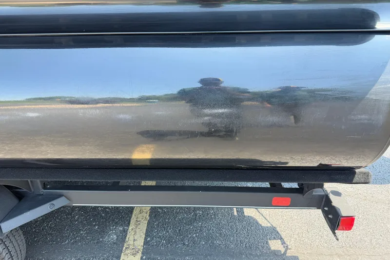 Slide: The Image of 2024 Regency R250DL3 boat trailer with reflective black surface in parking lot. - 8