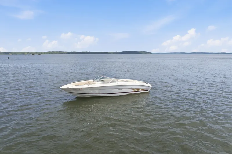 The Image of 1997 Sea Ray 230 Signature boat on calm water under a clear blue sky. - 0