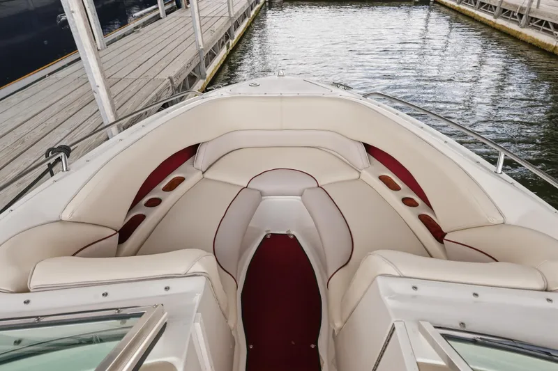 Slide: The Image of 1997 Sea Ray 230 Signature boat interior with white and red seating at dock. - 24