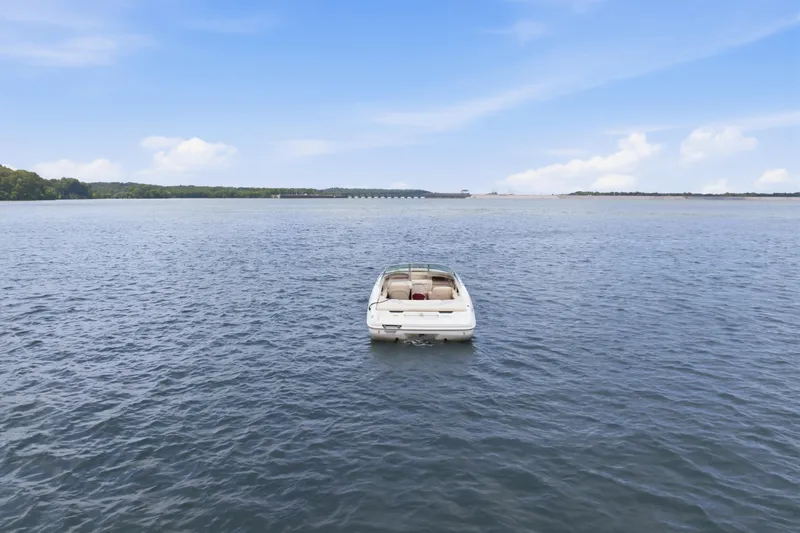 Slide: The Image of 1997 Sea Ray 230 Signature boat on calm water under blue sky. - 3