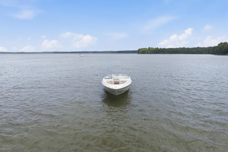 Slide: The Image of 1997 Sea Ray 230 Signature boat on calm lake under clear blue sky. - 5