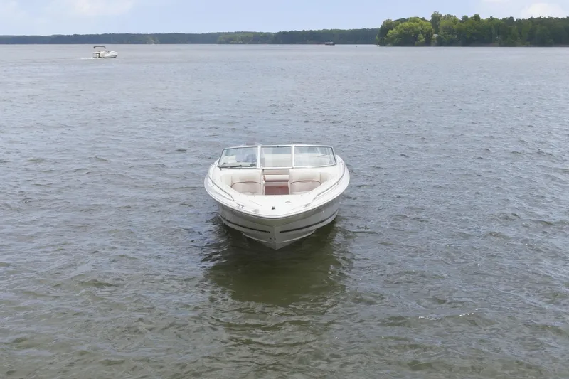 Slide: The Image of 1997 Sea Ray 230 Signature boat on calm lake under clear blue sky. - 6