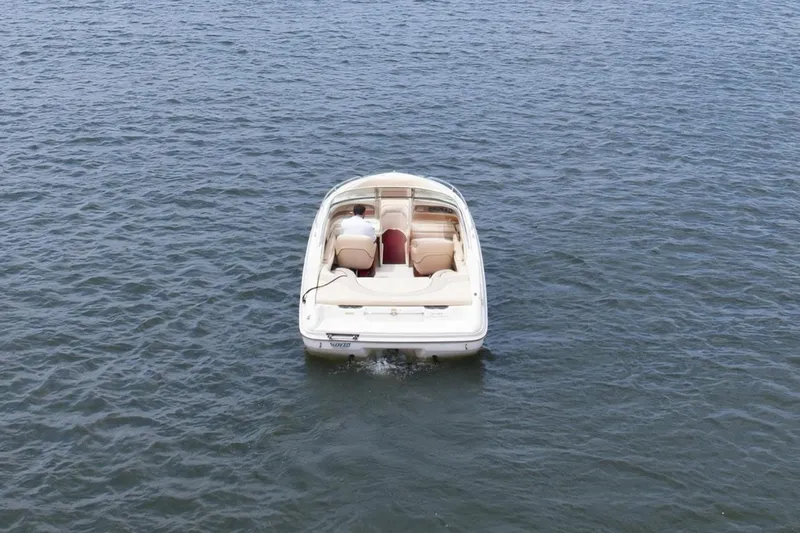 Slide: The Image of A 1997 Sea Ray 230 Signature boat on a calm lake under a clear blue sky. - 3