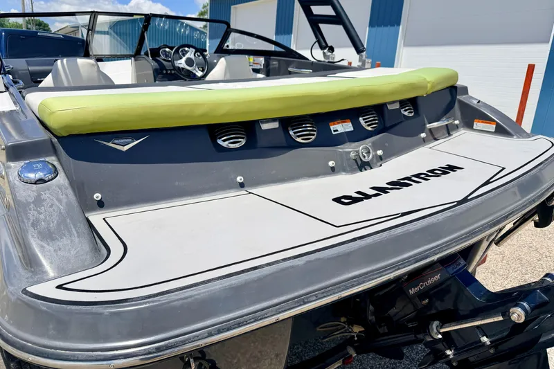 Slide: The Image of 2018 Glastron GT 185 boat with green cushion and MerCruiser engine, docked outdoors. - 19