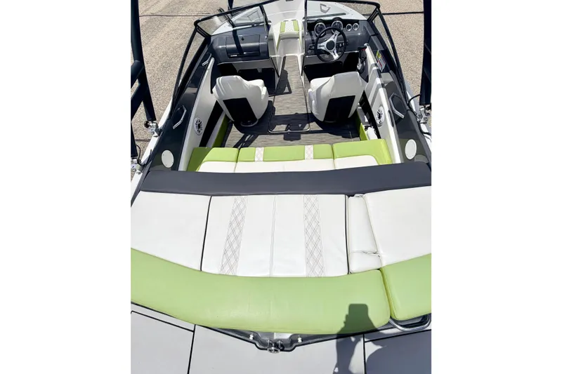Slide: The Image of 2018 Glastron GT 185 boat interior with green and white seating, steering wheel, and dashboard. - 22