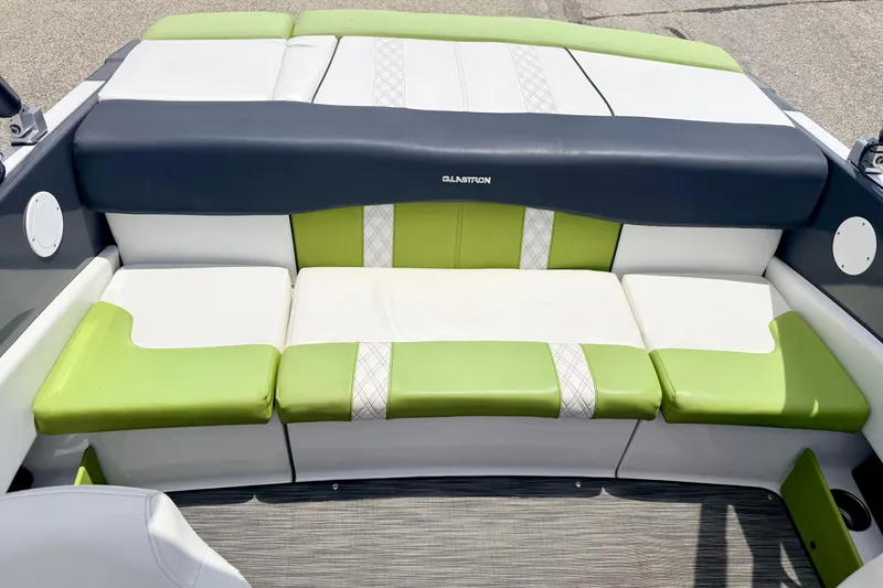 Slide: The Image of 2018 Glastron GT 185 boat interior with green and white cushioned seating. - 23