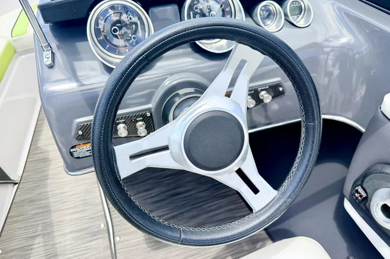 Slide: The Image of Steering wheel and dashboard of 2018 Glastron GT 185 boat, featuring modern gauges. - 34