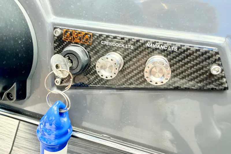 Slide: The Image of Control panel of a 2018 Glastron GT 185 boat with ignition key and switches. - 37