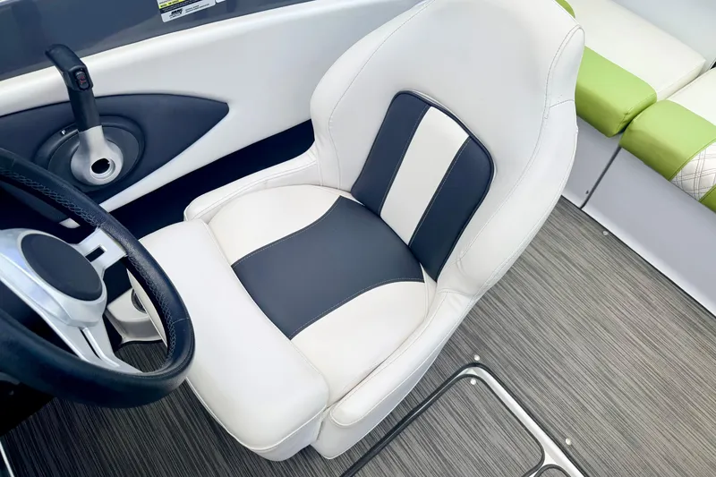 Slide: The Image of 2018 Glastron GT 185 boat interior with white and black captain's seat and steering wheel. - 38