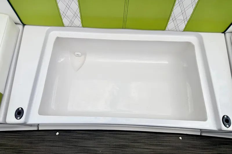 Slide: The Image of 2018 Glastron GT 185 boat interior with green and white seating and storage compartment. - 46