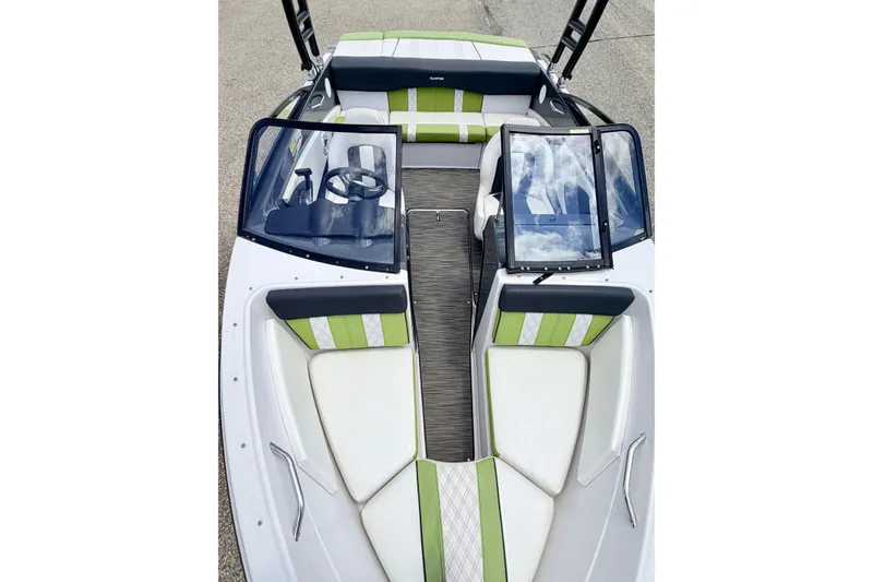 Slide: The Image of 2018 Glastron GT 185 boat interior with green and white seating, open windshield, and steering wheel. - 61