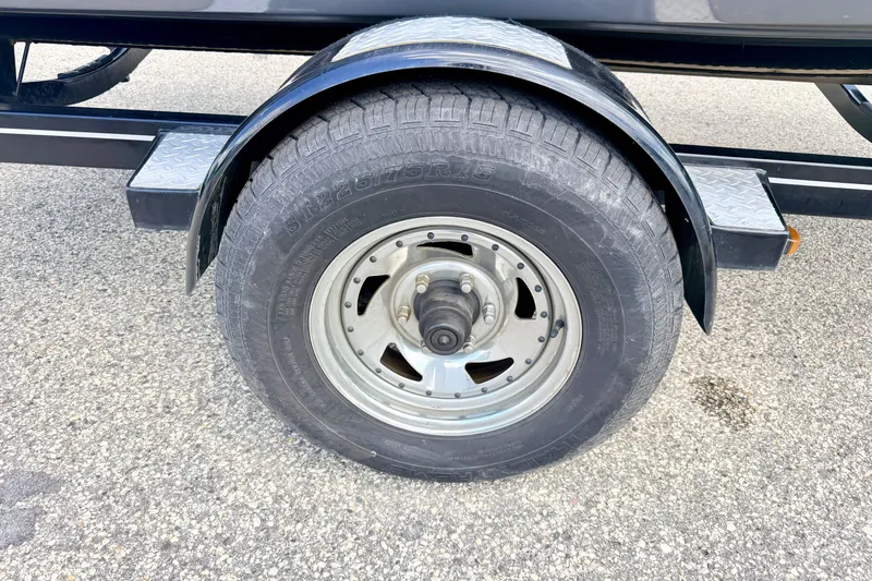 Slide: The Image of Trailer wheel of a 2018 Glastron GT 185 on asphalt surface. - 69