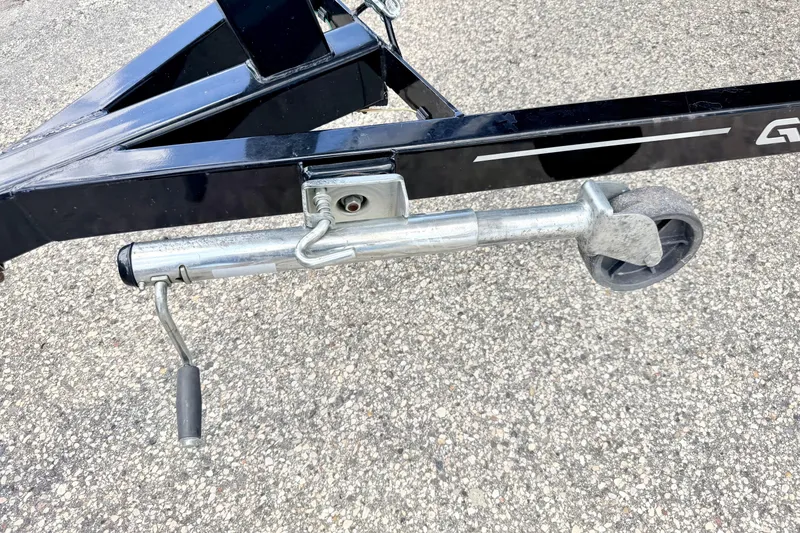 Slide: The Image of Trailer jack on a 2018 Glastron GT 185 boat trailer, parked on asphalt. - 72