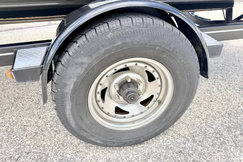 Slide: The Image of Trailer wheel of a 2018 Glastron GT 185 boat on pavement. - 73