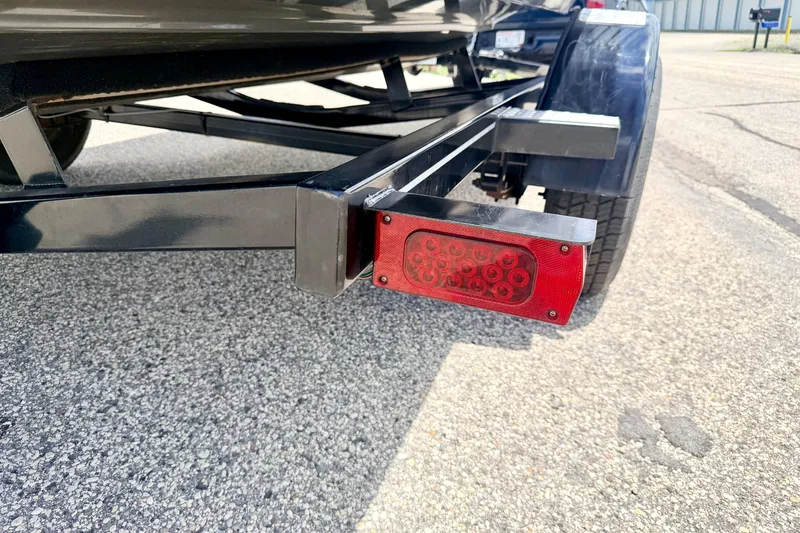Slide: The Image of Trailer light and wheel of a 2018 Glastron GT 185 boat on pavement. - 75
