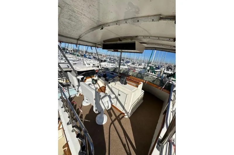 Slide: The Image of 1985 Egg Harbor 33 Sedan boat interior with helm, marina view, and seating area. - 11
