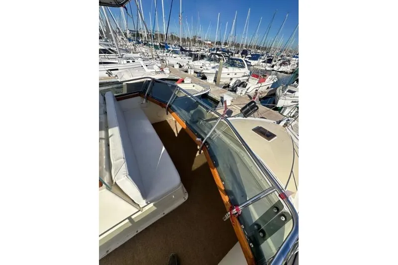 Slide: The Image of 1985 Egg Harbor 33 Sedan boat interior with marina view, featuring seating and windshield. - 14
