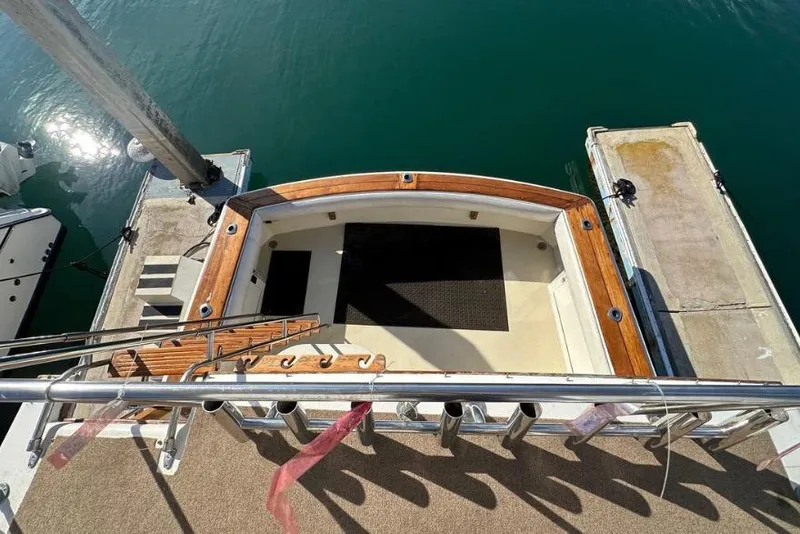 Slide: The Image of 1985 Egg Harbor 33 Sedan boat docked, featuring a wooden deck and stainless steel railings. - 17