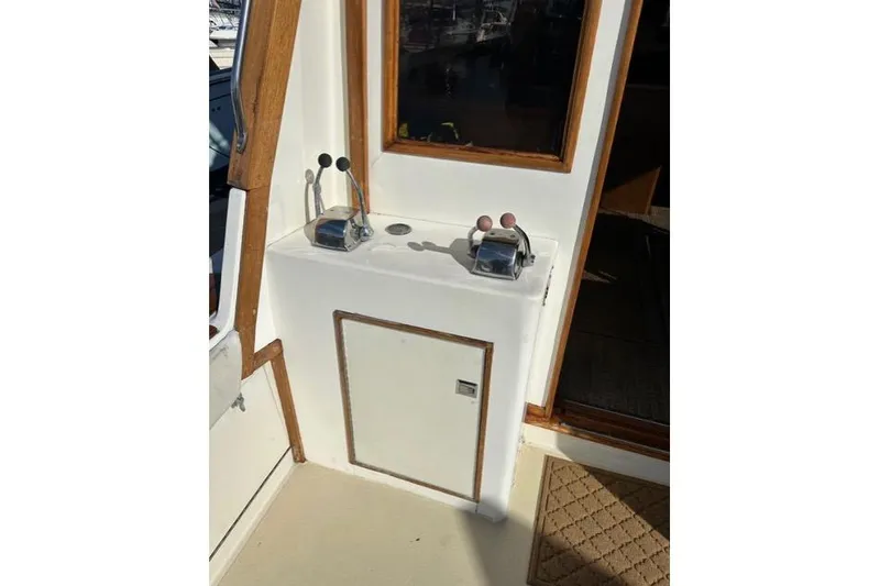 Slide: The Image of 1985 Egg Harbor 33 Sedan boat controls with wooden trim and door. - 19