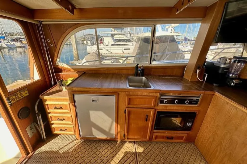 Slide: The Image of Interior of 1985 Egg Harbor 33 Sedan yacht with kitchenette and marina view. - 24