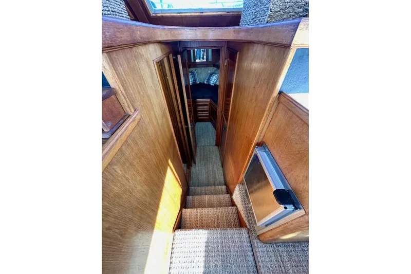 Slide: The Image of Interior view of 1985 Egg Harbor 33 Sedan, featuring wooden stairs and cozy cabin. - 31