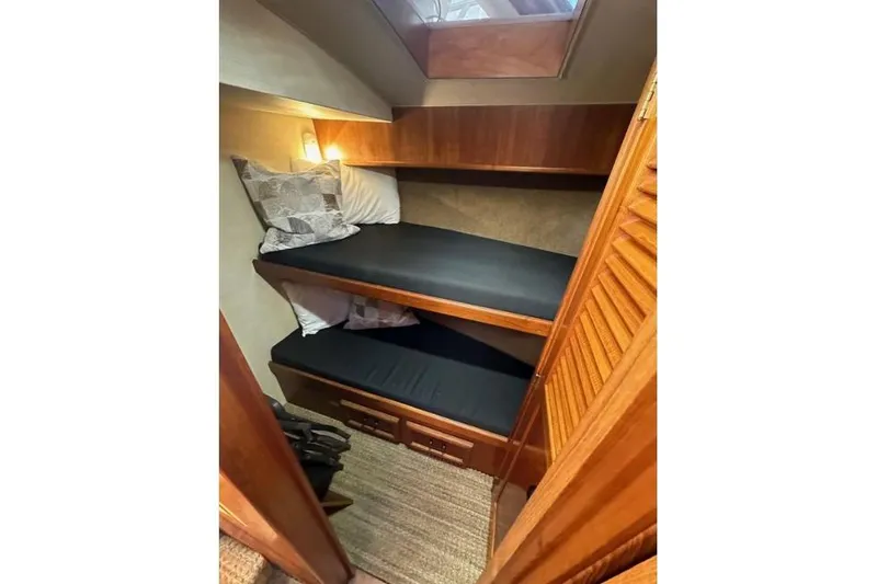 Slide: The Image of 1985 Egg Harbor 33 Sedan cabin with wooden bunk beds and cozy lighting. - 33
