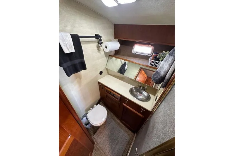 Slide: The Image of Bathroom interior of 1985 Egg Harbor 33 Sedan yacht, featuring sink, toilet, and storage. - 35