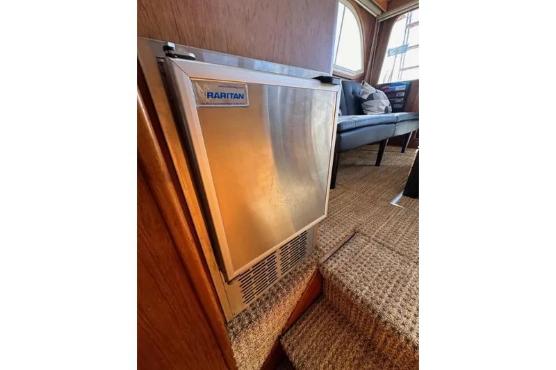 Slide: The Image of Raritan refrigerator inside 1985 Egg Harbor 33 Sedan yacht, with carpeted steps and seating area. - 43