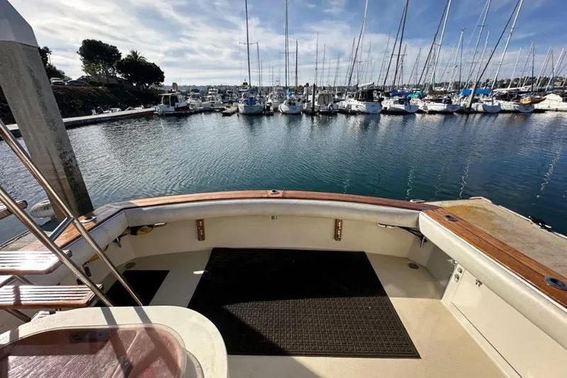 Slide: The Image of 1985 Egg Harbor 33 Sedan yacht docked at marina with sailboats in background. - 47