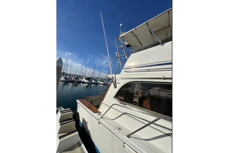 Slide: The Image of 1985 Egg Harbor 33 Sedan yacht docked at a marina under clear blue skies. - 5