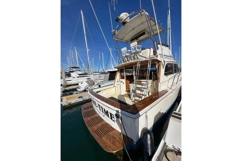 Slide: The Image of 1985 Egg Harbor 33 Sedan boat docked at marina, showcasing rear deck and upper helm. - 6