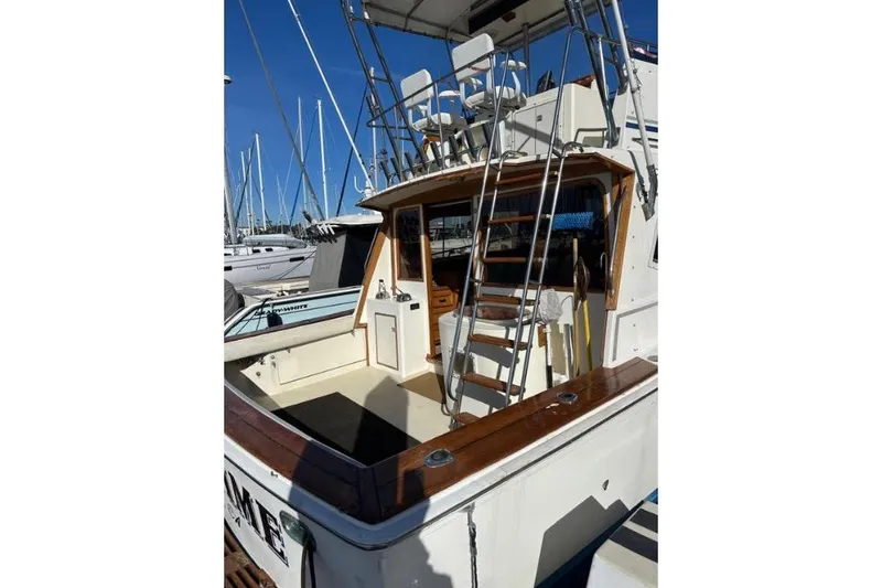 Slide: The Image of 1985 Egg Harbor 33 Sedan boat with ladder and seating, docked at marina. - 7